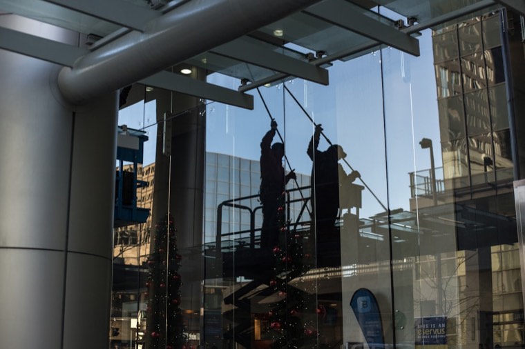A crew cleaning the glass of a commercial building